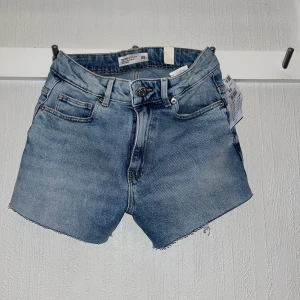 Blå jeansshorts från house  - Snygga blå jeansshorts  i storlek XS. De har en midwaist passform och fransiga kanter. Perfekta för sommardagar. Aldrig använt