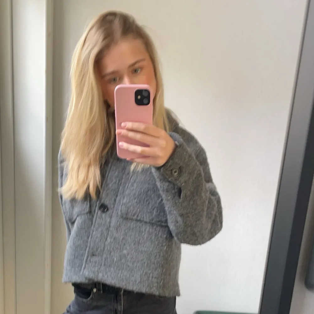 Säljer en stilren grå ulljacka från H&M. Jackan har en klassisk design med knappar framtill och en rak passform. Perfekt för kyligare sommar dagar och lätt att matcha med olika outfits.använd ett fåtal gånger så är i väldigt bra skick!❤️. Takit.