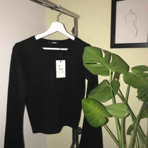  - En festlig topp som glittrar diskret. Vida, långa, ärmar och stretchiga material. Passar även S! 