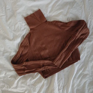  - Cropped stickat tröja i fin ljusbrun färg från Weekday. Köpt för några år sen men kanske använd 10 gånger totalt, så i bra skick.  Längd 36cm Omkrets 76cm Arm 61cm Mötas i centrala Stockholm OK Frakt (extra fraktkostnad) OK