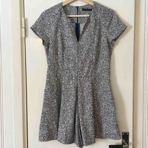  - Söt byxdress från Zara, inköpt för flera år sedan men knappt använd. Blå-vitt blommönster och en ficka på var sida av ”byxdelen”.  Dragkedja längs ryggen.