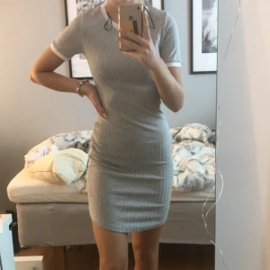 Grå klänning  - Lång grå ribbad klänning från hm med vita detaljer vid halsen och armarna. Använd 3 gånger så väldigt fint skick. Storlek Xs och säljer för 50kr