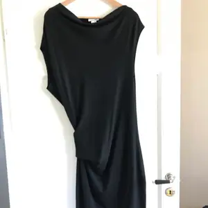 Asymmetrisk halvtight knälång klänning i lätt stretchigt tyg från Helmut Lang. Perfekt LBD! Aldrig använd o säljs pga fel stl. 