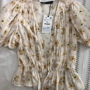 Zara topp - Har tagit bort prislappen nu! Så fin och somrig top med fluffiga ärmar. Frakt tillkommer på 49kr! Jättebra skick, knappt använd!