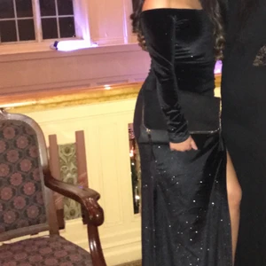 Långklänning skimrig - Skimrande svart långklänning med slits vid benet. Perfekt till bal/bröllop eller andra festligheter. Använd 1 gång.