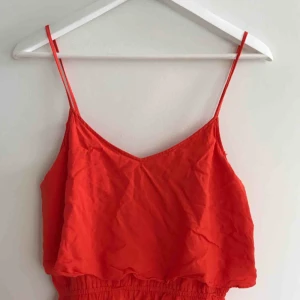  - Smultronröd klänning med resår i midjan. Justerbara axelband. Slutar ovanför knät. Använd ett fåtal gånger :) Frakt tillkommer <3 