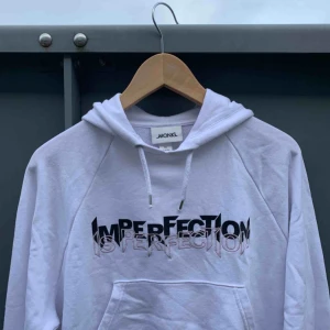  - En vit hoodie från Monki med lite kortare modell, men går över naveln.