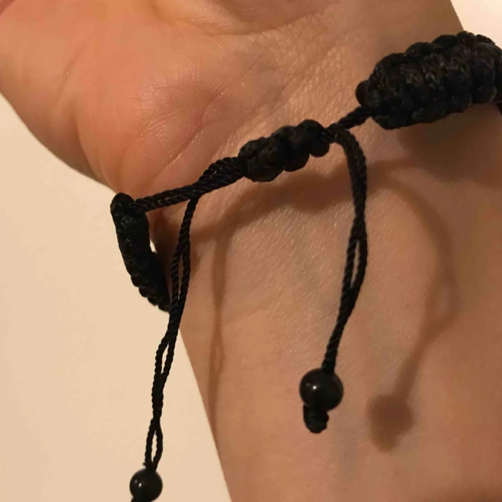Black bracelet, plastic and durable thread. Almost new. Bought in the US.. Accessoarer.