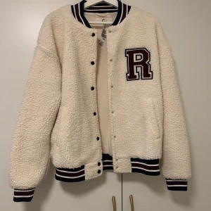 Baseball jacka i teddy - Förra annonsen raderades så lägger ut igen!! Säljer min snygga baseboll jacka, köpt second hand. Startbyd 300kr, buds i kommentarerna!!✨✨