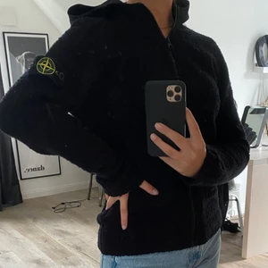 Stone Island zip hoodie  - En fleece imiterad Stone island junior zip-hoodie i storlek 12 passar lätt en 14 också! Passar både tjejer och killar. Jag är 16 år och den är lite lång i armarna för mig. Köpte den för 2700 i vintras. 100% äkta! Bara använd 2 gånger alltså väldigt bra skick, för mer information eller om du har några frågor, tveka inte att skriva