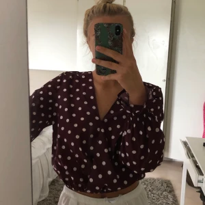 Prickig blus - Prickig blus från NaKd i polyester💜 och färgen vinröd! Super fin tillsammans med vita byxor eller svarta kostymbyxor🍷