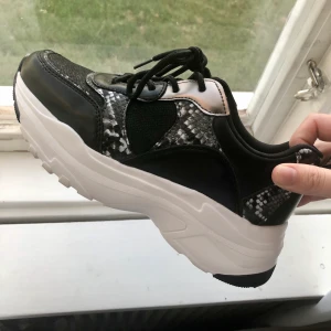 Knappt använda sneakers i ormmönster  - Säljer dessa as snygga och bekväma skor i storlek 37 då de ej kommer till användning! De är svarta och vita med detaljer i ormmönster, skimrar även på det svarta tyget på skon ✨ Använt 1 gång och finns därför få tecken på användning. 270 kr + frakt 