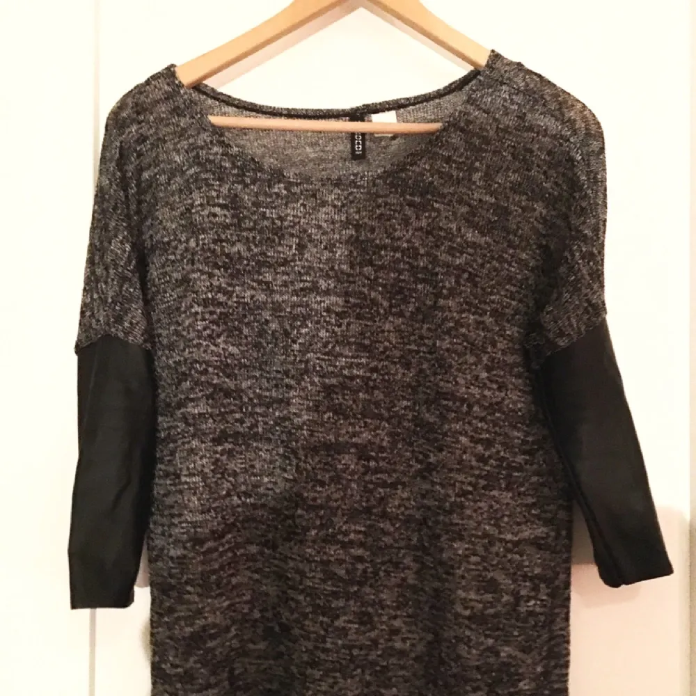 Grå/svart tunnt stickad långärmad tröja med ärmar i skinnimitation, från H&M. . Toppar.