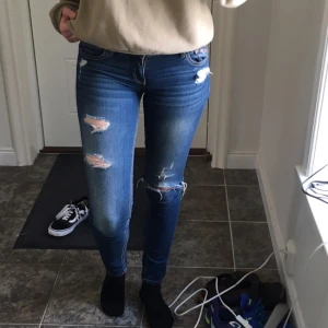  - Jättesköna jeans från hollister i stretchigt material! Jeansen hade hål på låret och knät när jag köpte dem, så det är menat till att vara så. Säljer eftersom de är för små för mig runt midjan och rumpan. Är storlek 27 ungefär. Så dessa skulle passa en 25a/26a. Skriv gärna ifall det finns andra frågor om passformen!       Frakt är ej inkluderat i priset 