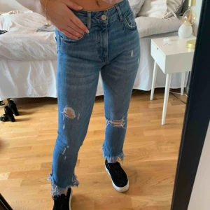  - Jeans med slitningar ursprungligen från Zara. Mellanhögmidja och lite stretchiga. Storlek 34. Jeansen är i bra skick. 