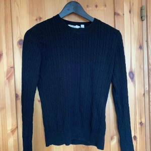  - En svart kabelstickad tröja , bra skick. Köparwn står för frakten. 