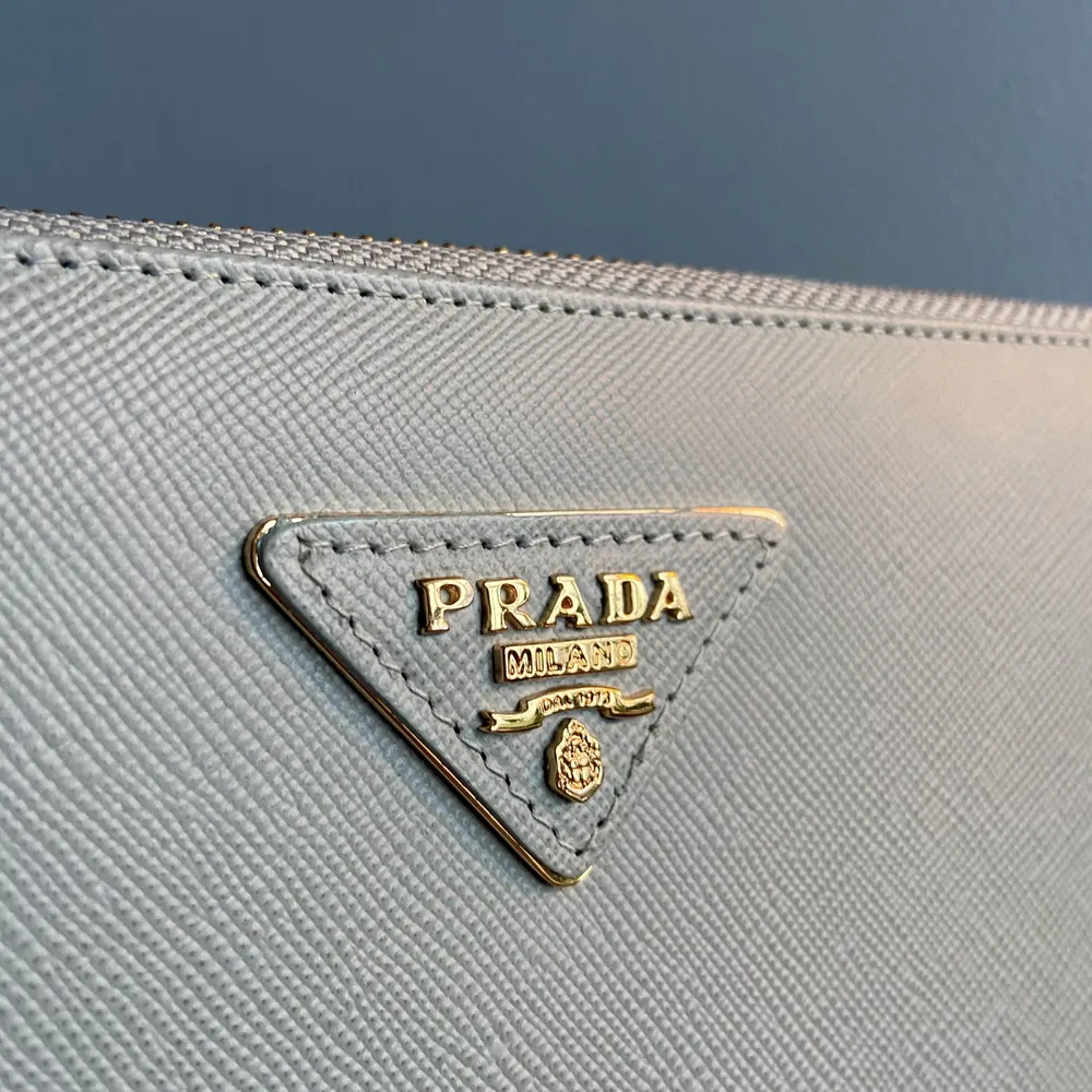 Prada replika plånbok/clutch i ljusblått skinn. 20cm x 11cm, aldrig använd, köpt i vintagebutik i London men ser helt ny ut.. Väskor.