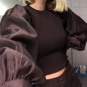 Brun tröja - En super fin tröja med puffiga armar! Den är i storlek medium men den är av stretch så skulle kunna passa både en strlk ner och uppåt!🥰 frakt tillkommer annars kan jag mötas upp!