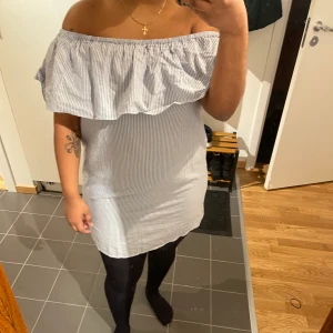 Fria axlar, blåvit randig klänning i skön bomull från Nelly - I gott skick. Tanken är att den ska sitta lite lösare än den gör på mig!