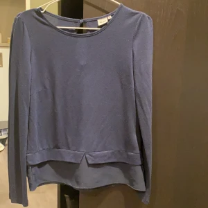 Marinblå topp  - Marinblå långärmad topp med fin detalj längst ner. Sparsamt använd! 