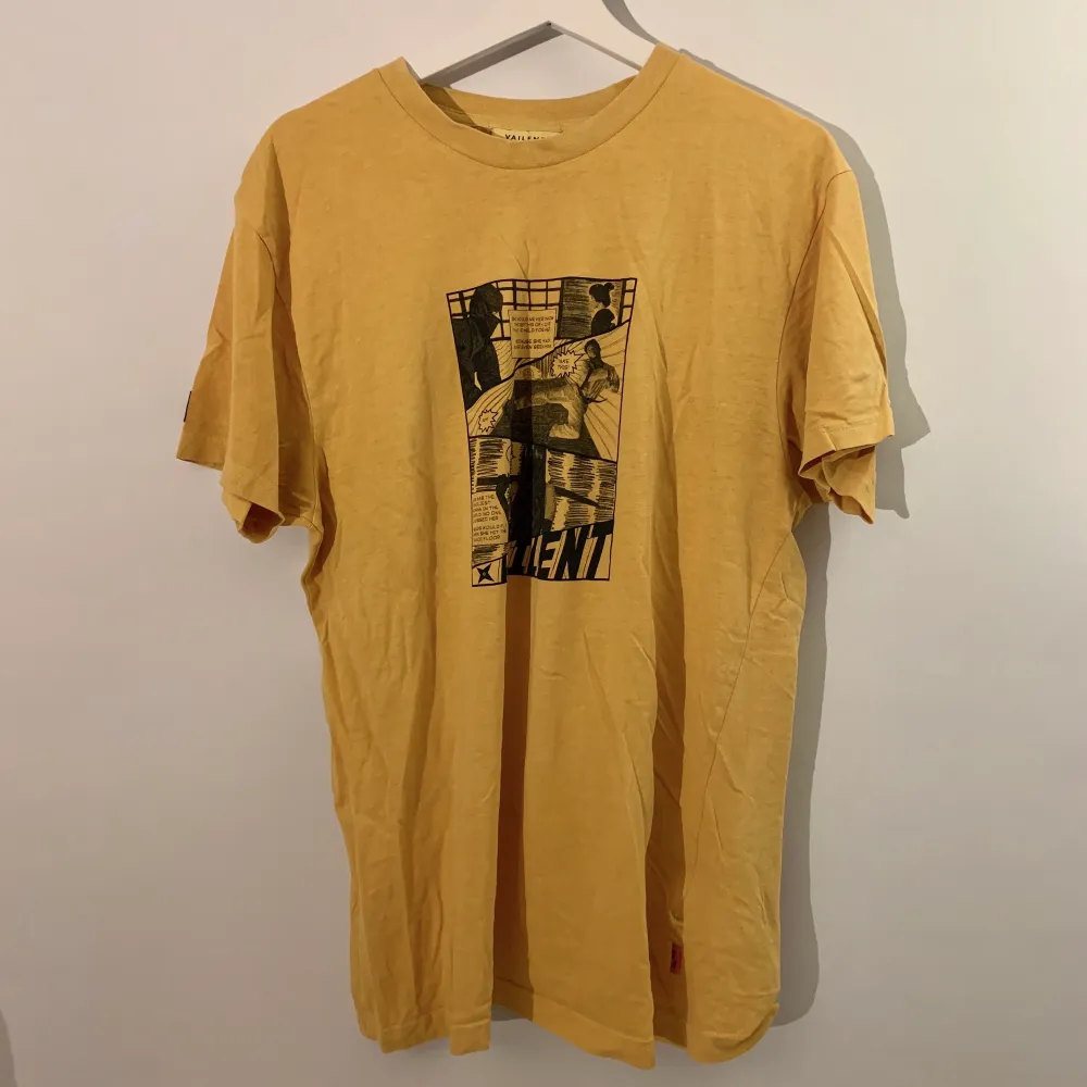 gul t-shirt med serietryck fram på! använd 2/3 ggr och köpt på carlings:). T-shirts.
