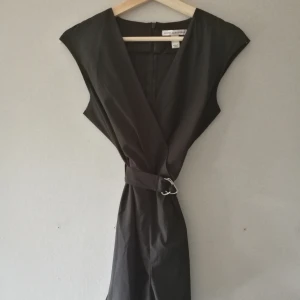 Snygg Byxdress från Sanne Alexandra  - Byxdress till festen. Storlek S. Sitter snyggt, tight på och med fin detalj med skärpet. 