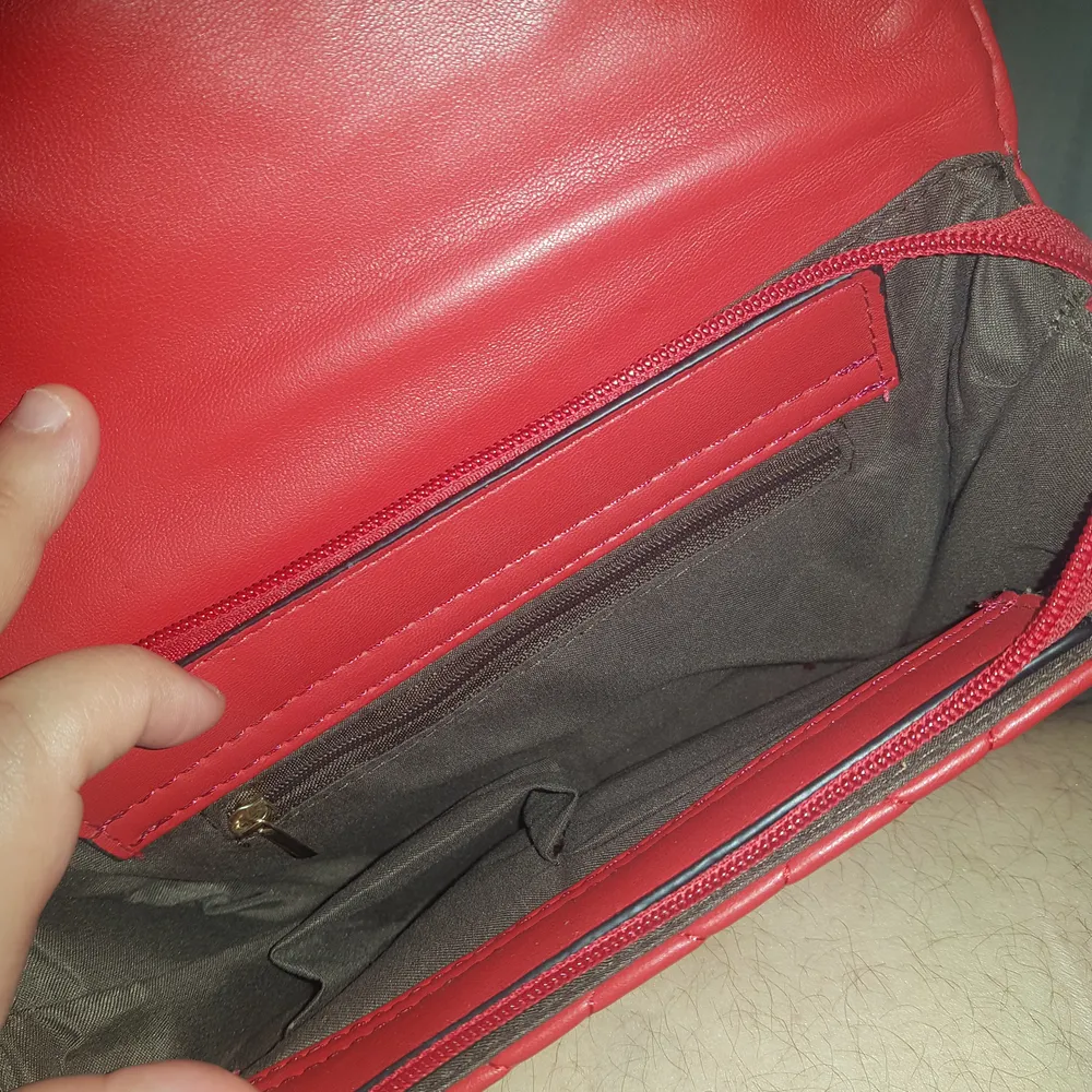 Helt ny röd väska med nitar från och bak jätte fin med kedje band . Väskor.