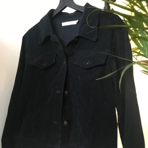 Svart jacka - Manchesterjacka/skjorta. Står small men skulle säga att den är mer som xs i storleken.