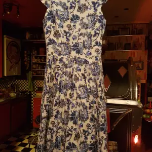 En fin klänning beige /vitmed blåa blommor på i storlek S. Frakt 66 kr spårbart