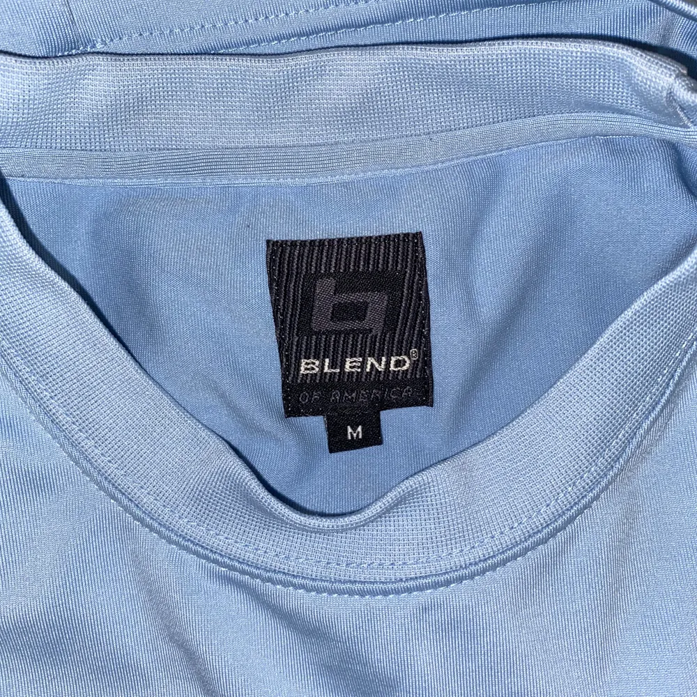 en ljusblå fin t-shirt som är gjord av mestadels polyester, med en cool reflexstripe på bröstet. frakt tillkommer!. T-shirts.