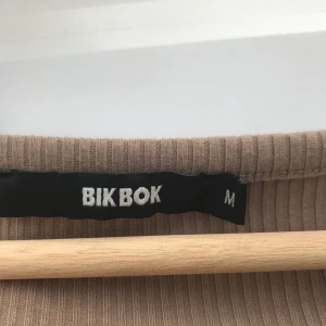 BikBok - Snygg T-shirt med spetts på nedre kanten och en liten urringning uppe. De är oanvänd och i storlek M. Säljs pga ser den helt enkelt är förstor. Jag kan tvätta den innan den skickas om det skulle önskas. Budgivning om det är många intresserade🥰