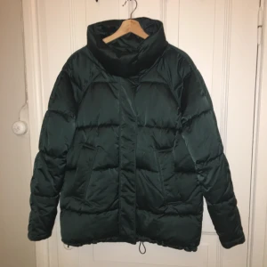 Dunjacka Monki - Super skön och varm dunjacka från Monki. Metallic grön i färgen. Strl M. Knappt använd!