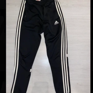 Adidasbyxor  - Ett par svarta adidas byxor i storlek 164, använda men är i bra sick! Plus har två dragkedjor.