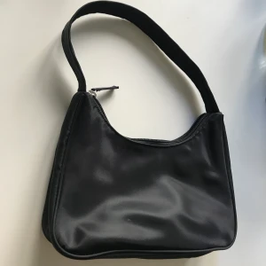 Oanvänd svart axelväska i nylon, Monki  - Svart nylonväska i populär modell. Köpt på Monki, endast prövad. 