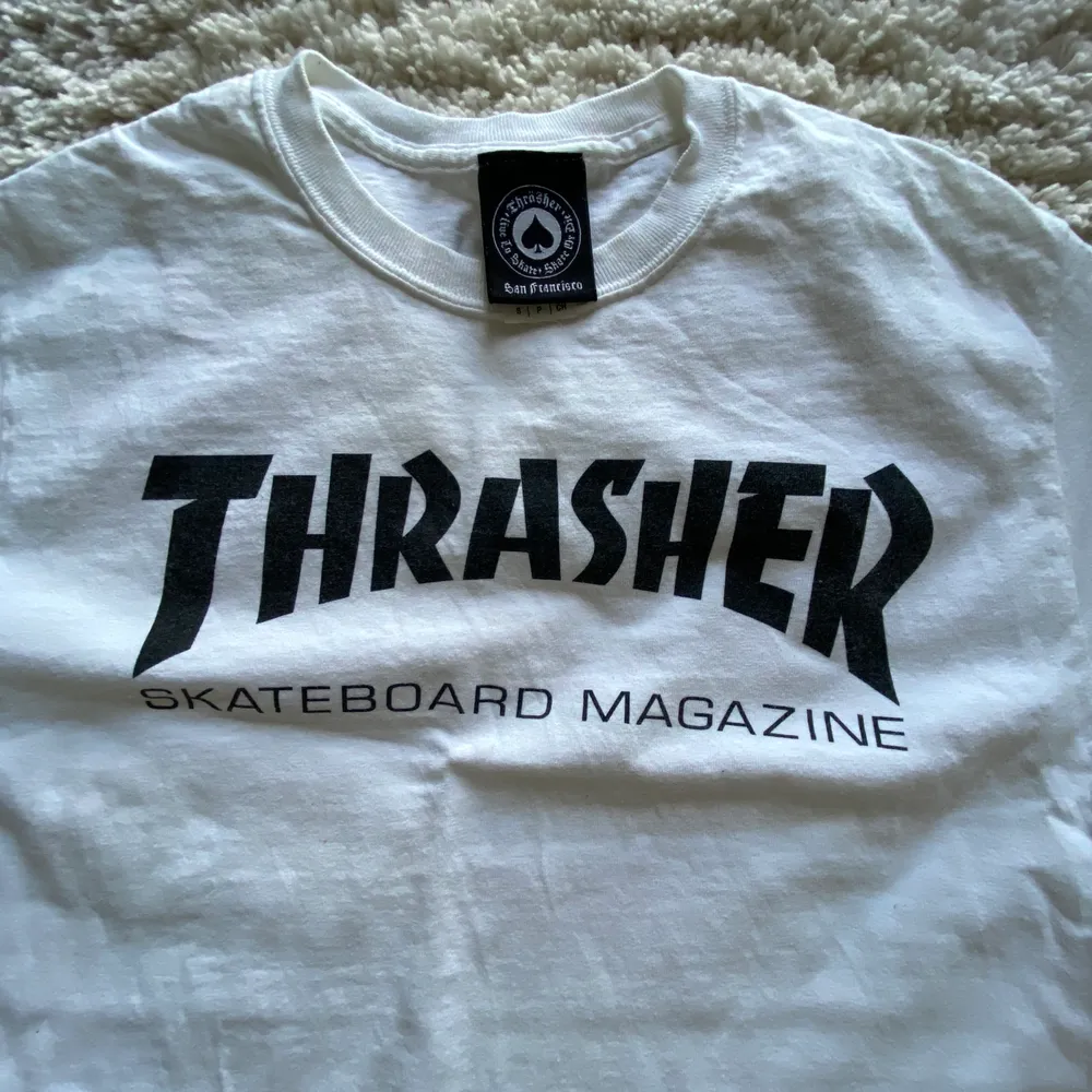 Vit supersnygg THRASHER T-shirt i storlek S men är en aning stor så funkar som M likaså. Använd Max fem ggr och legat i garderob oanvänd i något år så superfint skick! . T-shirts.