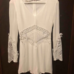  - Fin vit jumpsuit i storlek 10. Jättebra skick och endast använd ett fåtal gånger. Perfekt till sommaren eller student/skolavslutning. Köpt på madlady för något år sedan. Spetsdetaljer på armar och mage. Fler bilder kan skickas