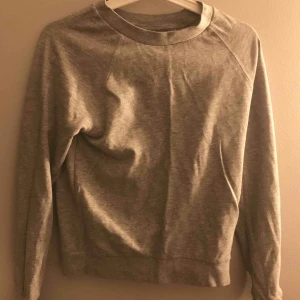  - En långärmad grå tröja. Skön och väldigt snygg till ett par blåa jeans!