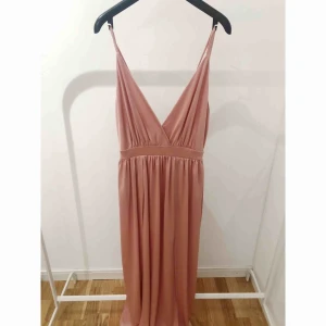  - Rosa långklänning med två slitsar från Nelly. Använd en gång. Storlek S. Nypris 500 kr. 