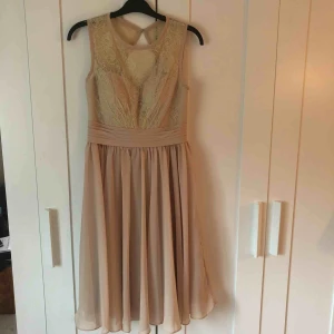  - Beige klänning som når nedanför knäna. Anv en gång . Uppsydd i Frankrike speciellt till ett bröllop på ett slott i Tyskland:) köparen står för frakt.