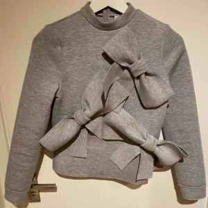  - Älskar denna tröja med den är för liten för mig. Väcker garanterat uppmärksamhet. I tjockare material (tänk dykardräkt) med stora rosetter som härlig och rolig detalj. Märke Lost Ink