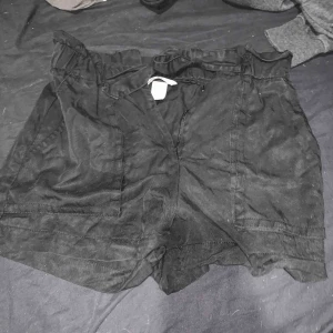  - Högmidjade shorts med snören för rosett fram. Stora fickor. Använda några gånger.  30kr ink. Frakt!
