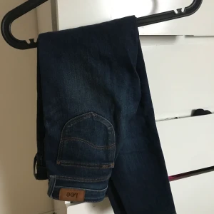 Blå jeans från Lee - Ett par blå jeans från Lee. Modellen är tajt med en normalhög midja. Är för liten för mig så kommer inte till användning. Nypris 1000