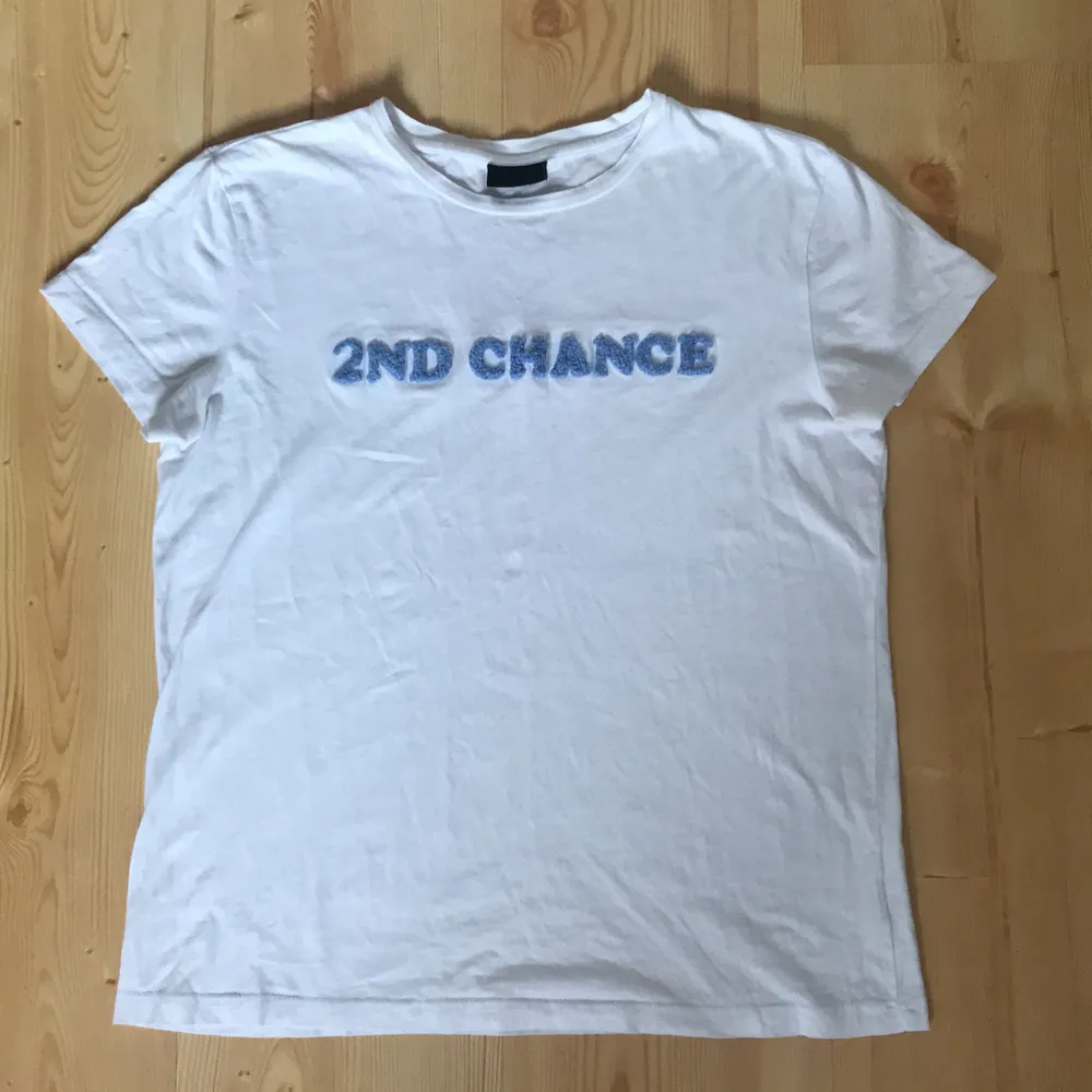 Vit T-shirt med texten ”2nd chance”från 2nd day. Texturen på texten ser man på andra bilden. Texten på lappen har suddats ut, men jag har för mig att storleken är M. Funkar lika bra på en S.. T-shirts.