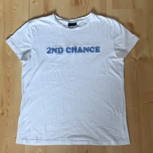 2nd day T-shirt  - Vit T-shirt med texten ”2nd chance”från 2nd day. Texturen på texten ser man på andra bilden. Texten på lappen har suddats ut, men jag har för mig att storleken är M. Funkar lika bra på en S.
