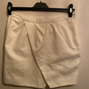 Vit kjol NLY TREND  - Super fin kjol med omlott inspirerad framsida med dragkedja på höft. 