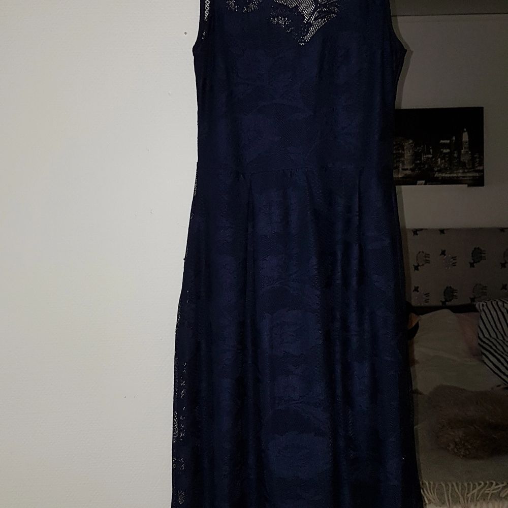 Mörkblå medellång klänning i blommigt spetstyg. Klänningen är i storlek 40 och är bra i storleken, inte för stor för att vara en 40. Jag har själv köpt den begagnad men den är i ett fint skick.. Klänningar.