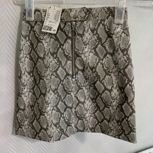 Snake kjol från hm - En orm printad kjol som är väldigt fin men tyvärr för liten för mig. Den är helt oanvänd har prislappen på sig. Frakt betalas av köparen