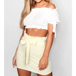 Gul/Vit rutig kjol men volanger  - Strl 40 men jätteliten i storlek så passar 34/36 . Väldigt söt med volanger och knytning från Boohoo. Prislapp kvar och aldrig använd. Säljer för 80kr 