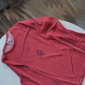 Dösnygg röd meshtopp - Röd meshtopp med så snyggt motiv både fram på bröstet och båda ärmarna! Skitsnyggt! Inte så jättegenomskinlig, lite lagom 