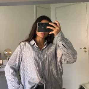 Oversized randig skjorta - Jättefin randig skjorta med ljusblå/vita ränder. Sparsamt använd och i nyskick. Jag är 160cm och den sitter snyggg oversized på mig.
